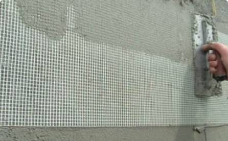 A man is plastering with white 5×5mm fiber glass cloth reinforcement