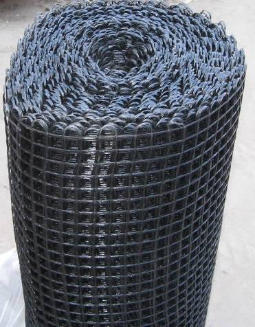 A roll of black fiberglass reinforcing mesh for road