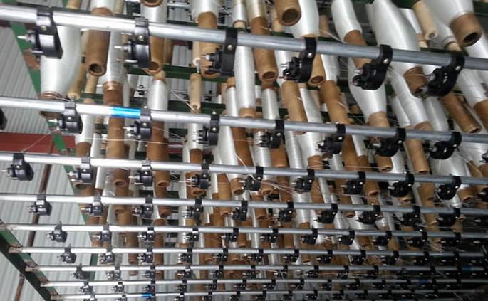 12 rows of white glass fiber yarn neatly arranged in the bracket ready to be woven